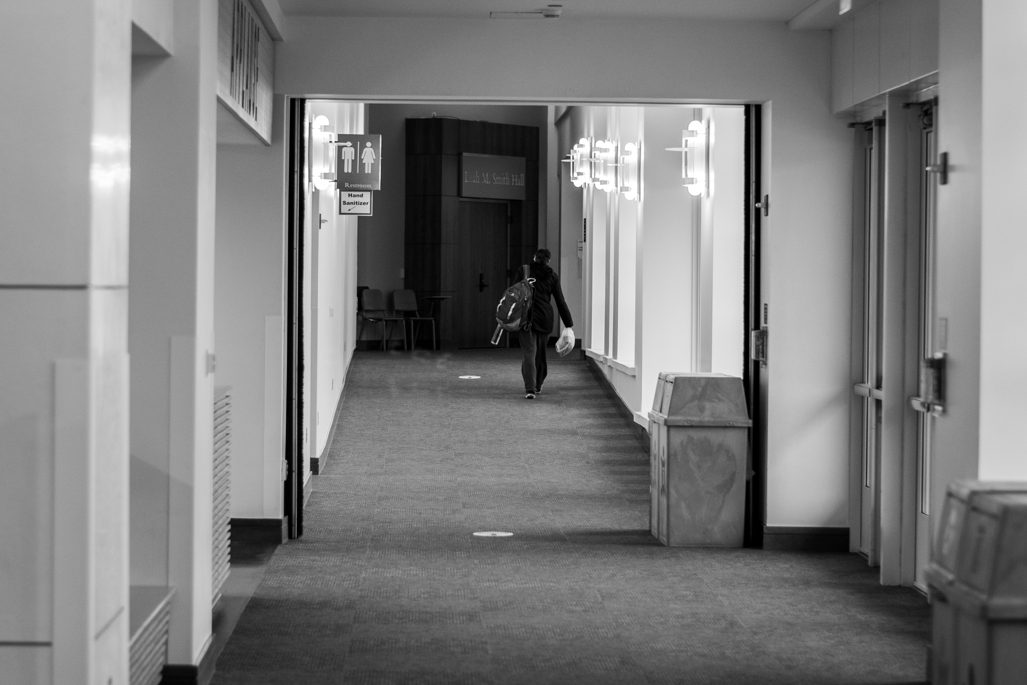 A person walks through an otherwise empty hallway