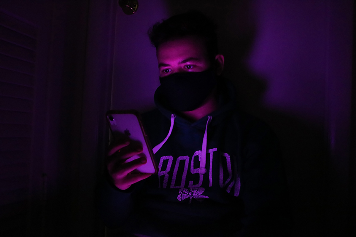 A man on his phone in a purple room
